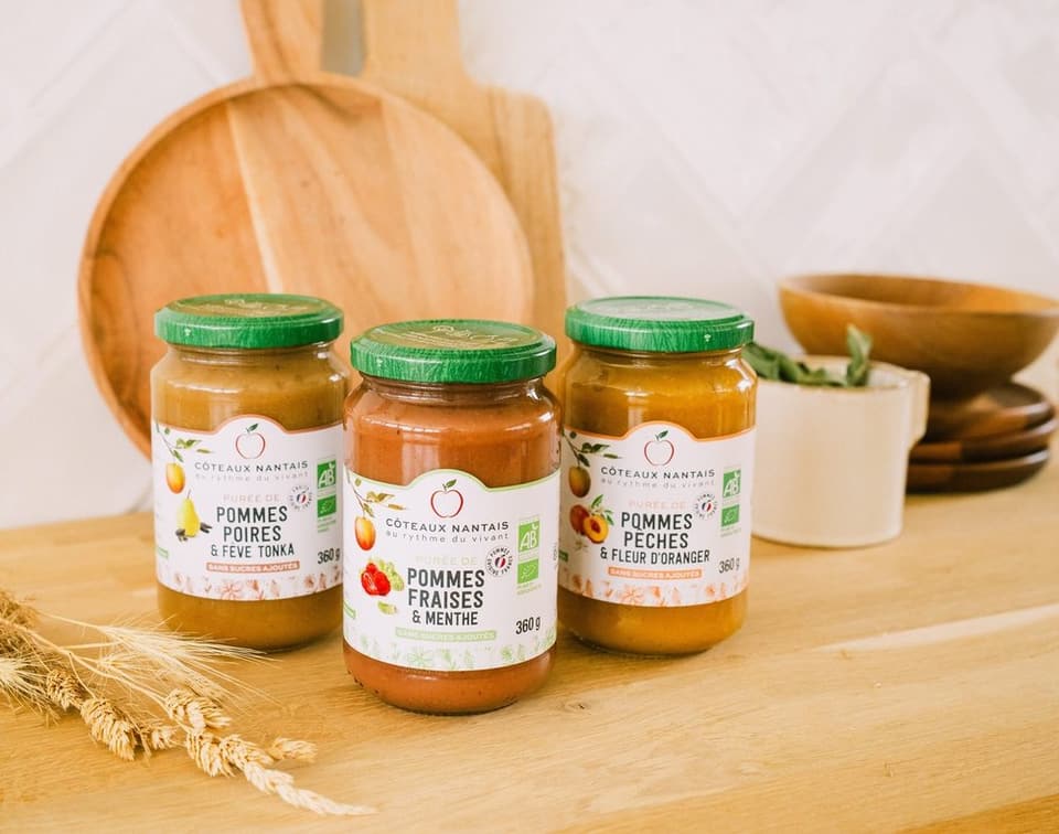 Three jars of apple compote on a wooden board